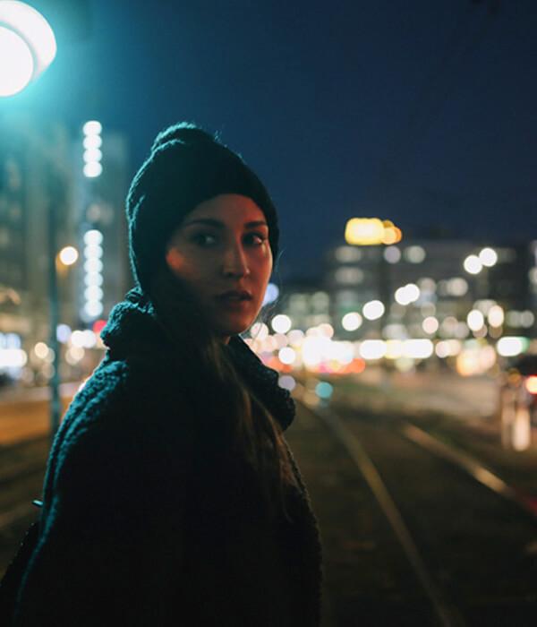 Banner image Woman on dark city street at night.