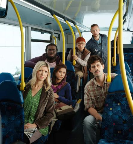 A group of people on a bus with concerned expressions on their faces. 
