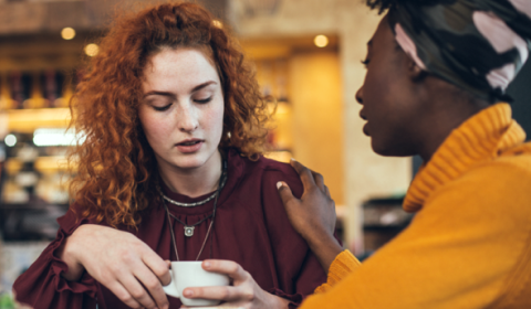 Two women talking over a cup of coffee.