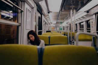 Woman sitting alone in a train carriage.